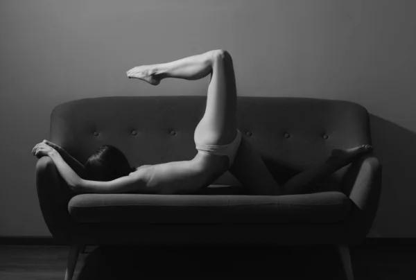 灵活性感的女人瑜伽女伸展着身体躺在沙发上 健身运动员女孩运动伸展 — 图库照片