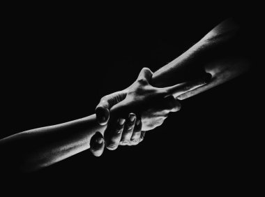 İki eğilim ve iki eğilim. Bir arkadaşa yardım ediyorum. Kurtarmak ya da el hareketlerine yardım etmek. Kurtuluş kavramı. Kurtarma sırasında iki güçlü insanın elleri, yardım edin. Siyah arkaplanda izole
