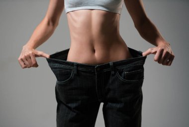 İnce bel. Kilo verme konseptinde büyük boy kadın pantolonu. Diyet konsepti olan büyük kotlu bir kadın