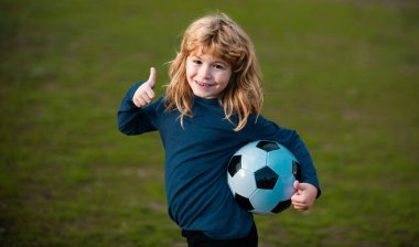 Futbolcu çocuk futbol oynuyor. Çocuk sahada futbol oynuyor. Gösteri başarıya işaret ediyor. Çocuklar futbol maçında gol attılar. Taraftar sporcu çocuk topu tutuyor