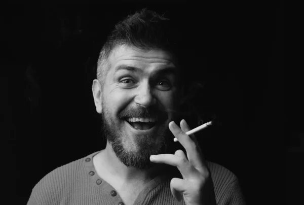 微笑的男人吸烟 把人的画像贴在黑色上 — 图库照片