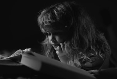 Küçük bir çocuk karanlık evde kitap okuyor. Çocukların yüzü gece lambasıyla kaplıdır. Yatmadan önce masal masalı