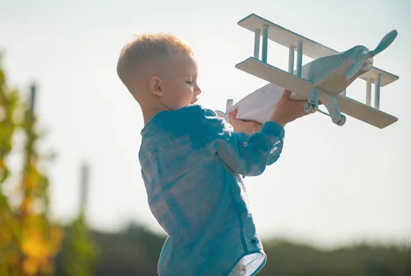 장난감 비행기를 가지고 다니는 어린이 조종사는 속에서 여름에 여행하는 꿈꿉니다 — 스톡 사진