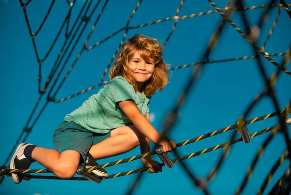 stock image Happy child boy playing on the rope outdoor playground