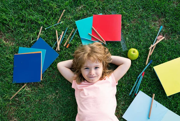 Dzieciak Szkoły Zabawnej Leży Trawie Uczenie Się Odległość Uczeń Chłopiec — Zdjęcie stockowe