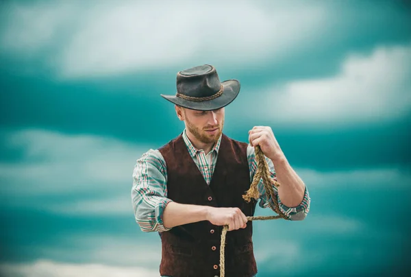 盖伊牛仔 农场的主人 农业工人和农业概念 穿着牛仔帽和乡村风格服装的英俊男子 带着套索在天空背景上 — 图库照片