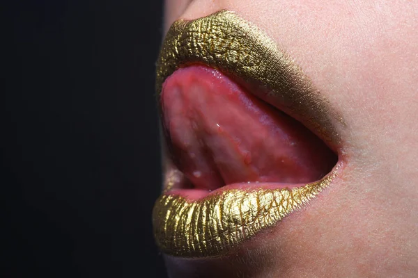 Sensual tongue licking lips. Golden glitter lipstick. Shine style for sexy lip. Sensual woman lips. Luxury golden mouth. Glamour gold lips. Golden lips with golden paint or metallic lipstick
