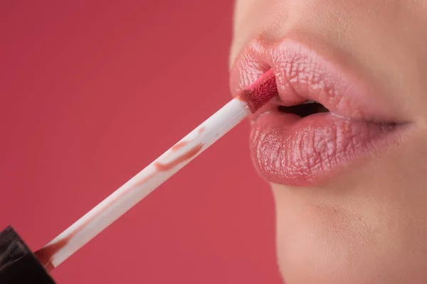 女孩用刷子把口红涂在嘴唇上 女性嘴唇用口红的特写 把口红涂在唇上 专业口红 — 图库照片