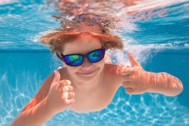 Çocuk havuzda oynuyor. Çocuklar tatil ve tatil konsepti. Yaz çocuğu yüzme havuzunda oynuyor. Havuzda suyun altında küçük bir çocuk. Çocuklar yaz tatilinde havuzda yüzerler.
