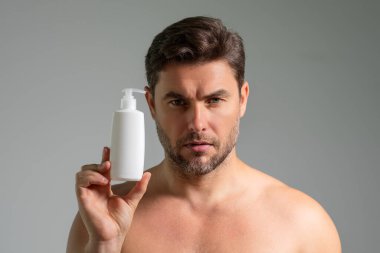 Kozmetik güzellik malzemeleri. Kozmetik şişeli bir güzellik uzmanı. Erkekler için doğal kozmetik kremi. Güzellik ürünleri. İnsan yeni kozmetik ürünlerinin reklamını yapıyor, kozmetik ürünlerinin reklamını yapıyor.