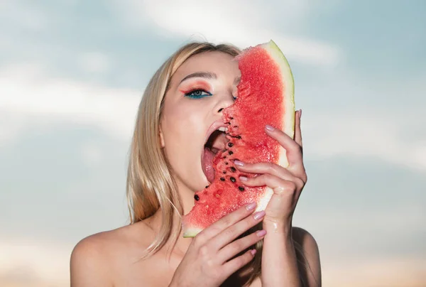 セクシーな夏のトロピカルフルーツ セクシーな口の中にスイカをかむ 官能的な若い女性はセクシーな舌でスイカを舐めます 顔の半分に対してスイカのスライスを保持若い女性 — ストック写真