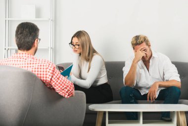 Aile içi sorunları sosyal hizmetler görevlisi ya da aile psikologu ile tartışan bir çift. Depresyon terapisi, aile terapisi.