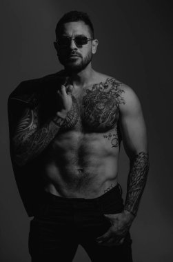 Moda ve seksi erkek model. Seksi bir adamın baştan çıkarıcı yüzü. Maço kendinden emin görünüyor. Moda erkek modeli, moda tarzı. Dövmeli ve zarif bir hippi.