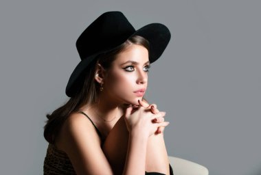 Şehvetli moda kadını yüzüne iyice bak. Siyah şapkalı seksi bir kadının güzel portresi. Vogue Biçimli Portre