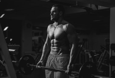 Kaslı adam yaya geçidinde. Crossfit spor salonunda çalışan genç bir adam. Sporcu adam egzersiz yapıyor..