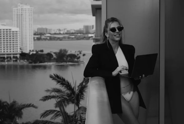 Sexy business woman. Beautiful secretary with laptop. Stylish business woman on office balcony. Sexy businesswoman in a suit