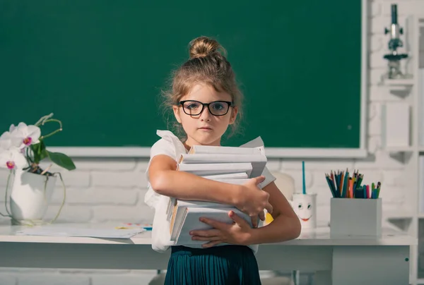 黒板に本が書かれたメガネのオタク女子高生 子供の女の子は学校でレッスンを学ぶ クラスの小学生 — ストック写真