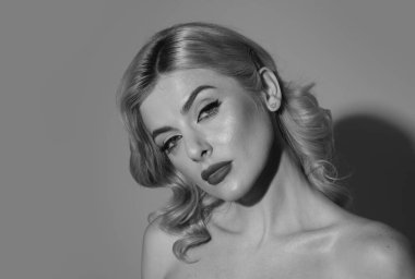 Güzel, romantik bir kadın yakın plan çekimde. Güzel lüks makyaj. Model kız portresi stüdyo arka planında. Temiz cilt ve parlak makyaj. Kırmızı rujlu seksi kadın dudakları. Değiştirilmemiş cilt