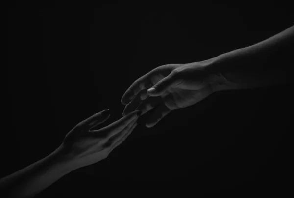 Two hands. Helping hand to a friend. Rescue or helping gesture of hands. Concept of salvation. Hands of two people at the time of rescue, help. Isolated on black background
