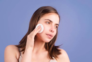 Pamuklu ped, sünger, pamuk yumağı olan güzel bir kadın. Cilt bakımı ve güzellik anlayışı. Kız pamuk yumağıyla makyajı siliyor. Deri bakımı konsepti. Pamuk ped kullanan kadın