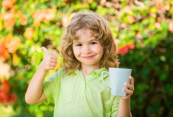 晴れた夏の日に若い男の子がカップからジュースを飲む屋外 — ストック写真