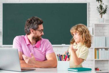 Teacher and child from elementary school learning at classroom