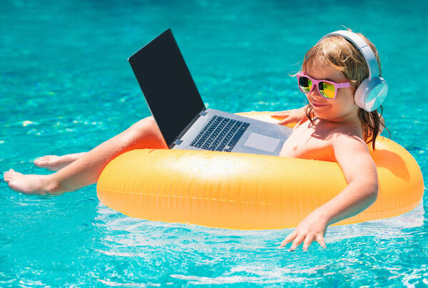 Freelance work concept. Child working on laptop computer at poolside swimming pool. Summer online technology. Traveler relaxing on tropical sea beach in summer holidays vacation. Business travel