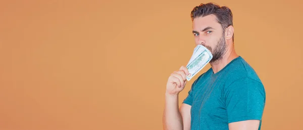 stock image Handsome man holding money isolated over beige studio, banner. Money in dollar banknotes. Pile of cash, finance, investment and money saving. Mockup banner