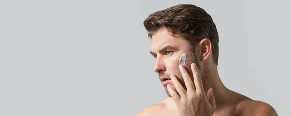 男性の美容化粧品 男性の美しさとスキンケア 人間のための朝の医療と衛生 完璧な美肌だ シャワーの後のハンサムな千年の人は皮の表面クリームかマスクを適用する ワイドバナー — ストック写真
