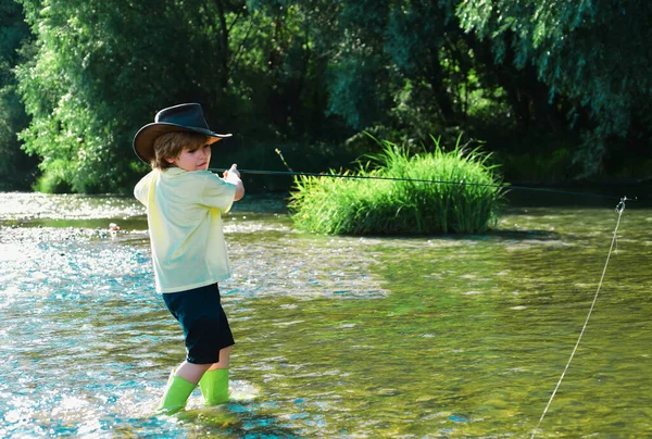 Little fisherman ready to go fishing. Young man fly fishing. Cute little boy fishing on pond. Kid learning how to fish holding a rod on a river