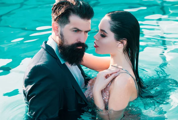 情侣们在游泳池里举行聚会 名人夫妇 时尚的一对优雅的人 恋爱中的浪漫夫妻站在游泳池里 — 图库照片