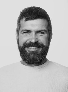 Sakallı adam. Mutlu adam gülen surat. Yakışıklı, gülümseyen genç adam. Berber dükkanında uzun sakallı ve bıyıklı bir berber. Olumlu insan yüz ifadeleri ve duyguları