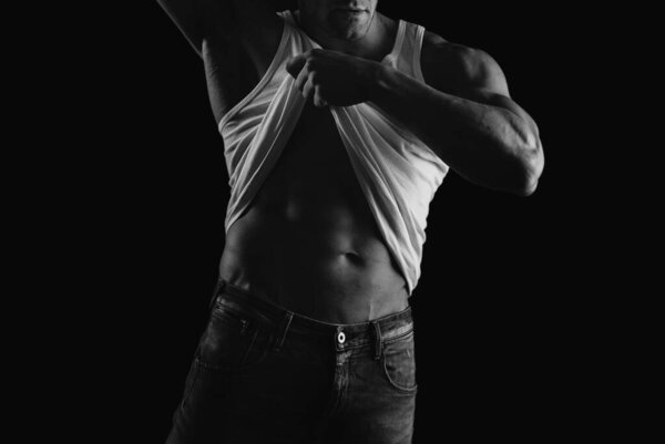 Naked man. Handsome shirtless muscular man standing in studio, isolated on black
