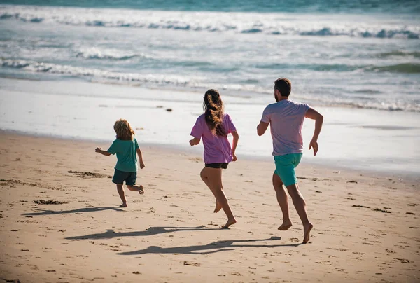 ビーチでジョギングをしている父 健康的な家庭生活をコンセプトとする 夏休みの海で — ストック写真