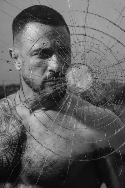 ガラスの弾丸の穴 破壊と粉砕テストの概念 砕いたガラスの後ろに機械男のガラスくず セクシーヒスパニック入れ墨男後ろ壊れたガラス — ストック写真