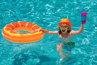 Yüzme havuzunda şişme oyuncak yüzüğü olan küçük bir çocuk. Çocuklar yaz tatilinde yüzerler. Şamandırada çocuk için yüz. Deniz ve deniz eğlencesi. Yaz çocukları kokteyli