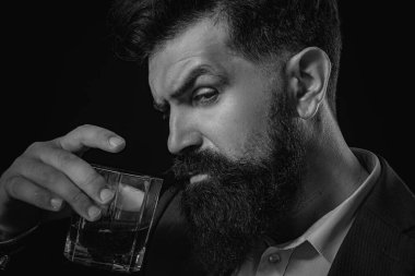 Bardakta viski kokteyli tutan sakallı adam. Yakın plan portre. Alkol iç.