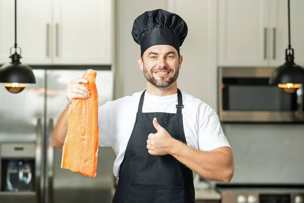 中年男子在厨房里煮鲑鱼 厨师在厨房里吃鲑鱼 天然蛋白质概念 健康食品概念 健康饮食 肉类蛋白质 — 图库照片