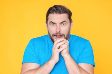 Duygusal olarak korkmuş bir adam korkmuş bir ifadeyle sinirli bir şekilde fobisini gösterir. İnsan tepkisi ve duyguları. Tüh. Dehşete kapılmış üzgün adamın yüz ifadesi parmaklarını ısırır.