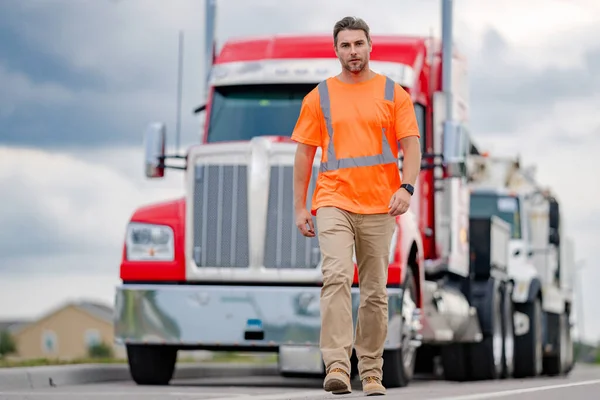 Men driver near lorry truck. Man owner truck driver in safety vest near truck. Serious hispanic man trucker trucking owner. Transportation industry vehicles. Handsome man driver front of truck