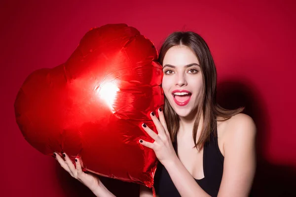 美丽的年轻女子与心形气球在工作室孤立的背景 情人节的女人 爱的心 女孩拿着红色气球的心脏 假日派对 心之爱概念 — 图库照片