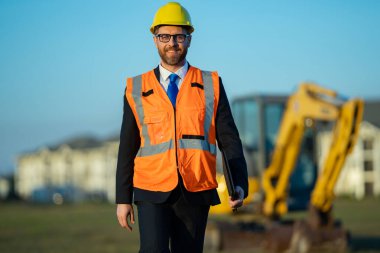 İnşaat alanında mimar. İnşaat alanında kask ve takım elbiseli mimar. İnşaatta duran kendine güvenen bir mimar. Yatırımcı ya da inşaat mühendisi. İspanyol 'un açık hava portresi