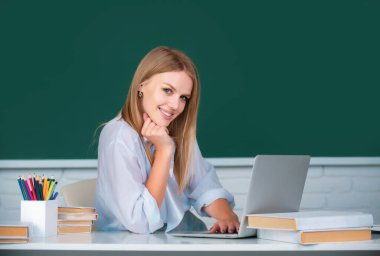 Sınıfta ders çalışan gülümseyen genç bir üniversite öğrencisi. Kameraya bakan neşeli üniversite öğrencisinin portresi