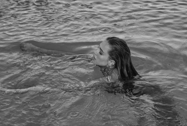 穿着泳衣的年轻女子正在游泳池里游泳 — 图库照片