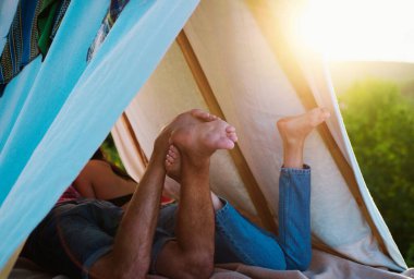 Yürüyüşçüler doğa üzerinde kamp yapar. Tatil kampında romantik aşıklar. Çadırdaki çiftin arka bacak görüntüsü. En iyi arkadaşım. Ayaklara odaklan.