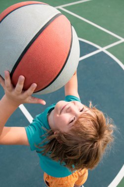 Küçük şirin bir çocuğun basketbol oynadığı portreyi yakından çek. Çocukluk ve spor konsepti