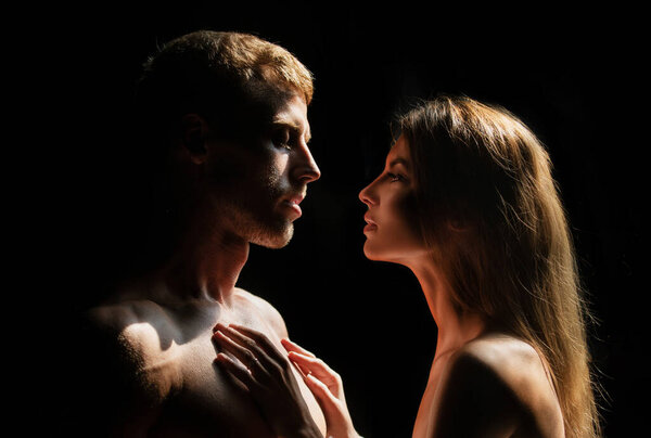 Sensual portrait of a sexy couple embracing while dating. Young couple in love on black. The lovely coupl spends time together
