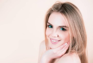 Güzel bir kadın yüzü. Sağlıklı cilde dokunan genç, güzel, güzel bir kadının yakın plan yüzü. Doğal dudaklar, makyaj. Gülümseyen kadın