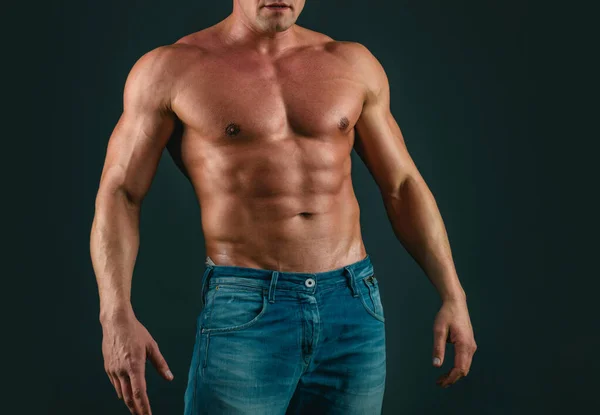 灰色の隔離された背景にジーンズの筋肉の強い男 理想的なフィットボディ 強い残忍な男のファッションの肖像画 筋肉セクシー男とともに胴 — ストック写真