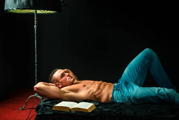 寝室でセクシーな男 ハンサムなシャツのない若い男読書A本でベッド — ストック写真